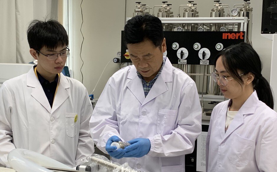 Professor GUO(in the middle) discussing research progress and findings with his team.